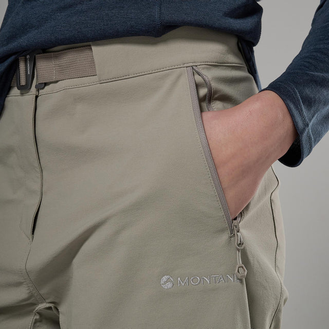 Close-up of beige shorts with a visible Montane logo on a grey background