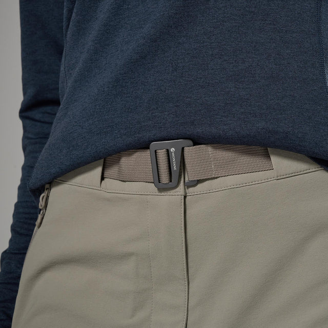 Close-up of a person wearing a navy long-sleeve shirt and beige pants with a brown belt.