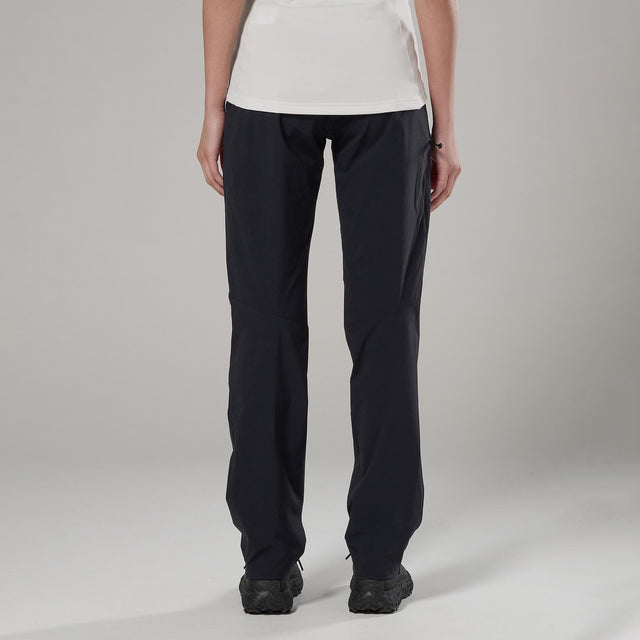 Person wearing black pants on a plain background