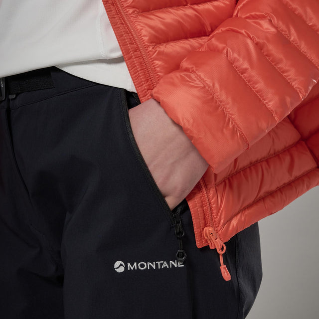 Person wearing a red puffer jacket and black pants with a Montane logo