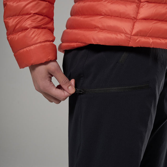 Person wearing a red puffer jacket and black pants against a grey background