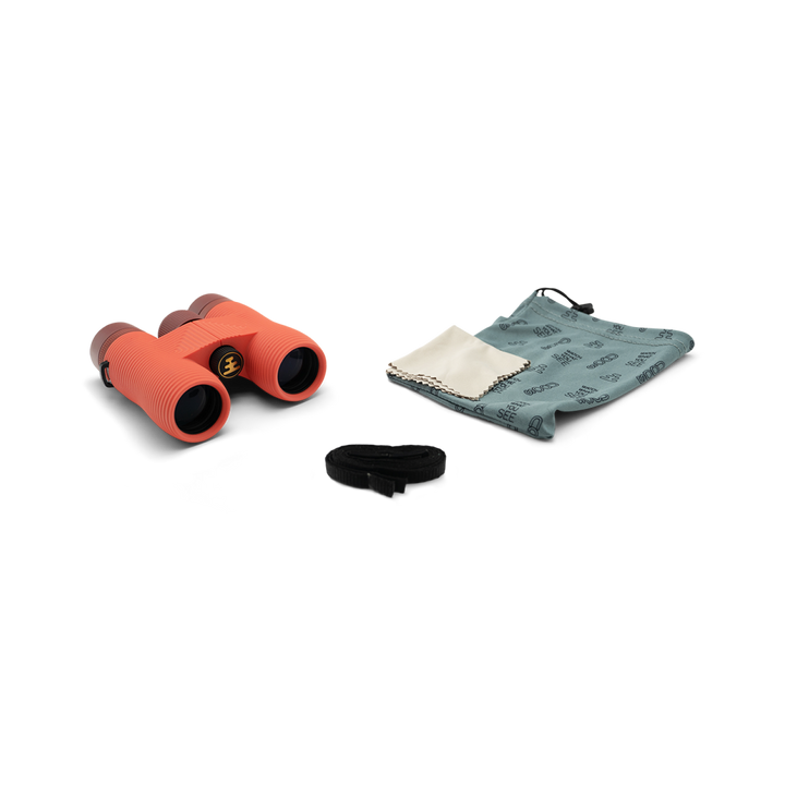 Compact orange binoculars with a cloth and case on a white background