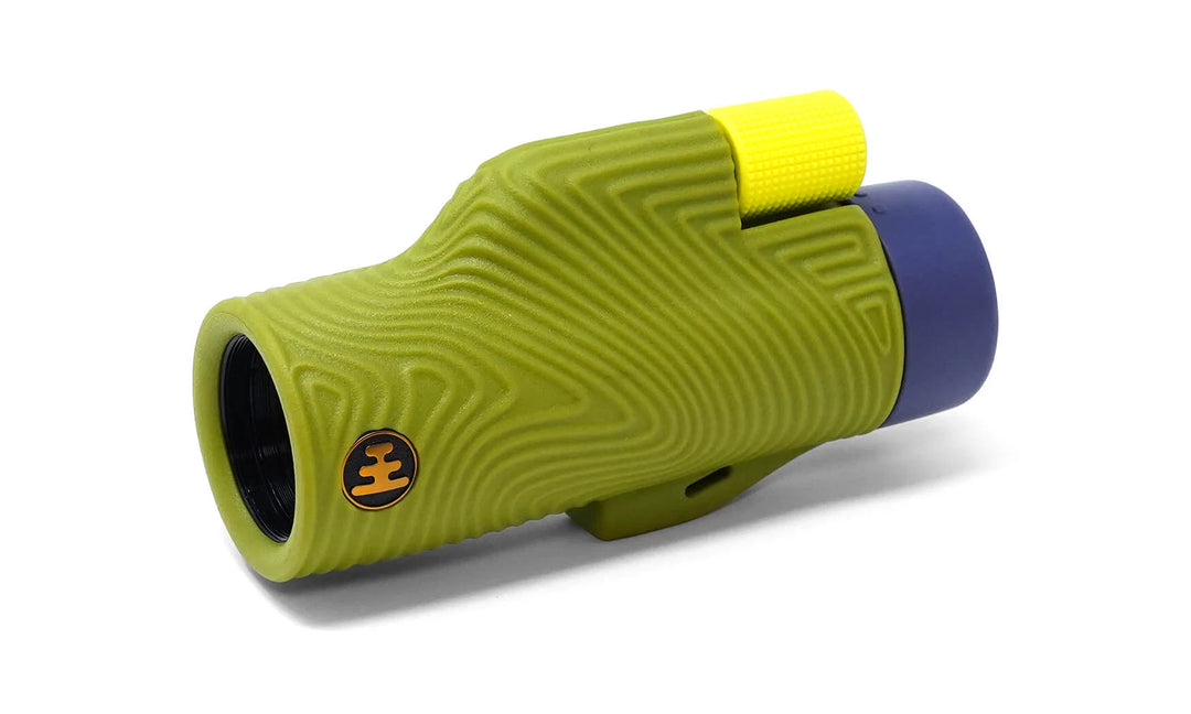 A single-lens spotting scope with a textured olive green protective cover, a bright yellow eyepiece, and a dark blue objective lens, shown on a white background.