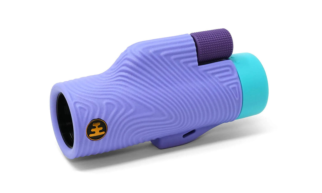 A purple and teal monocular spotting scope with a textured wavy grip pattern, shown on a clean white background.
