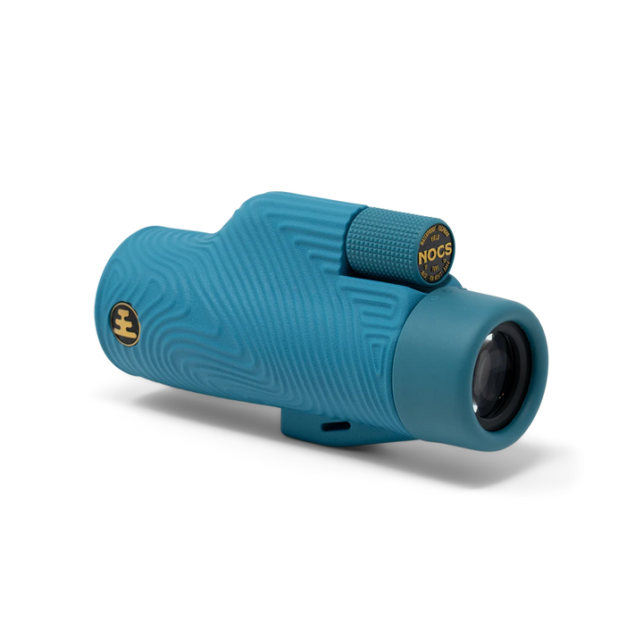 A teal blue monocular with a textured wavy pattern and gold accents, including a visible &