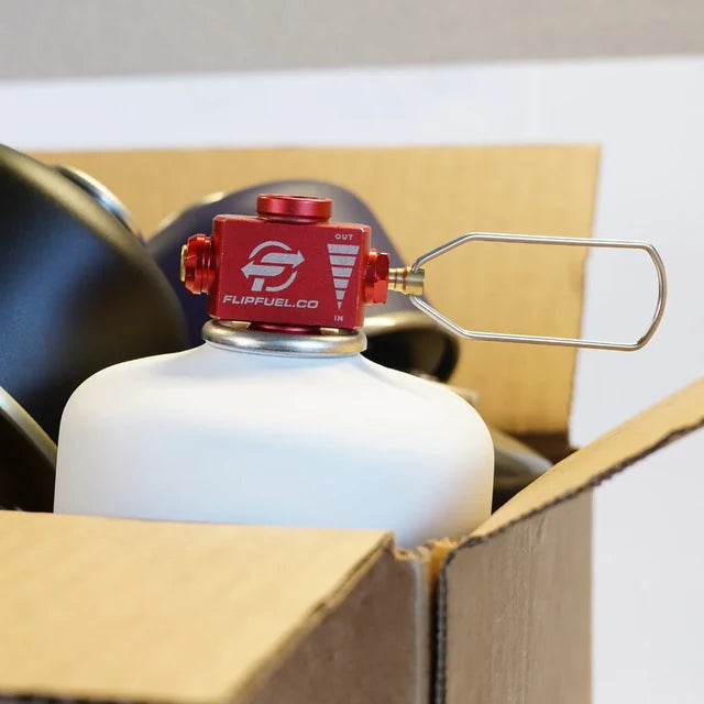 FlipFuel CO2 canister with red valve in a cardboard box