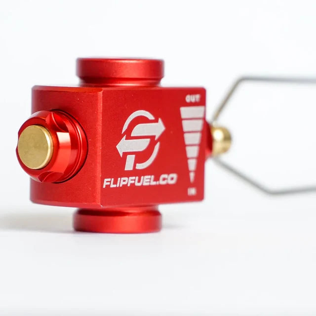 A close-up of a red anodized metal FlipFuel CO2 transfer bulb with a brass valve and a clear hose, on a white background.