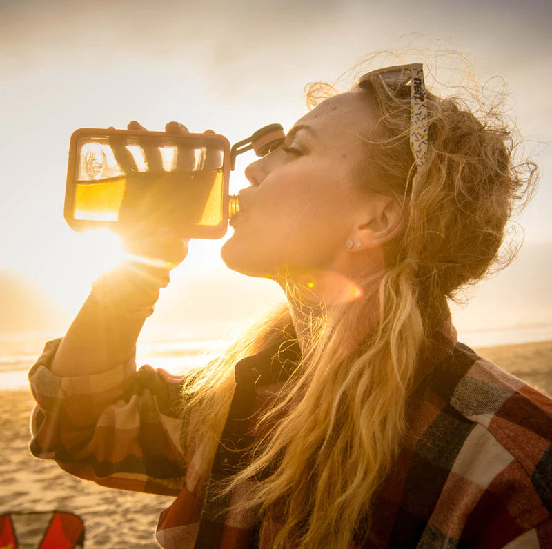 Person drinking from a flask with a scenic background