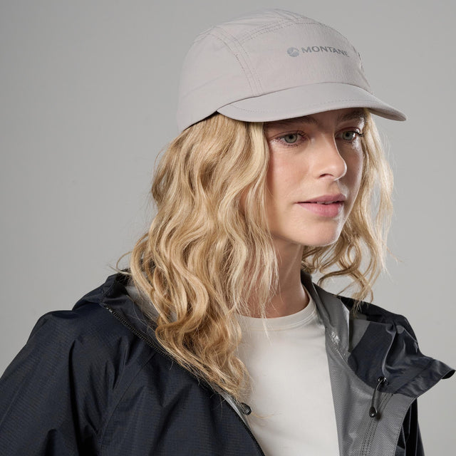 Woman wearing a light grey cap with &