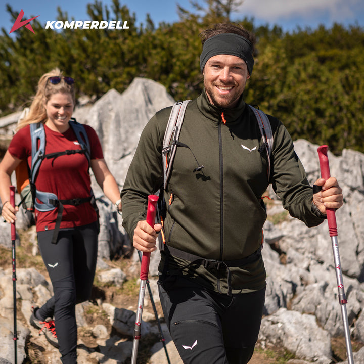 Two hikers with trekking poles on a rocky trail, Komperdell logo in corner