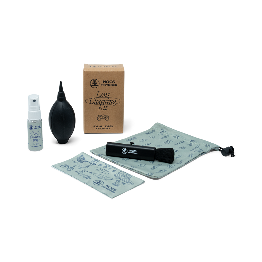 Nocs lens cleaning kit with spray bottle, blower, brush, and cloth on a white background