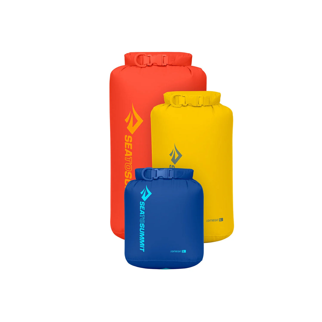 Three dry bags in red, blue, and yellow with visible brand logos on a white background.