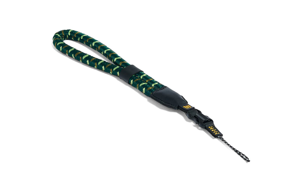 Green and black camera strap with a black clip on a white background