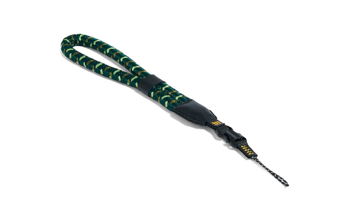 Green and black camera strap with a black clip on a white background