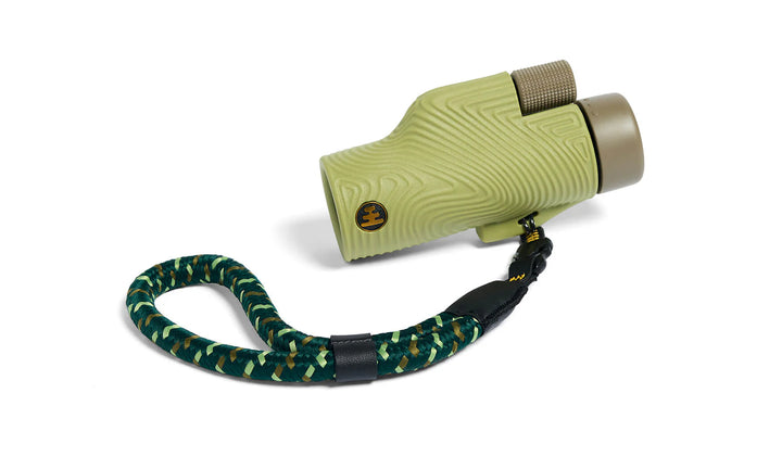 Green monocular with a strap on a white background