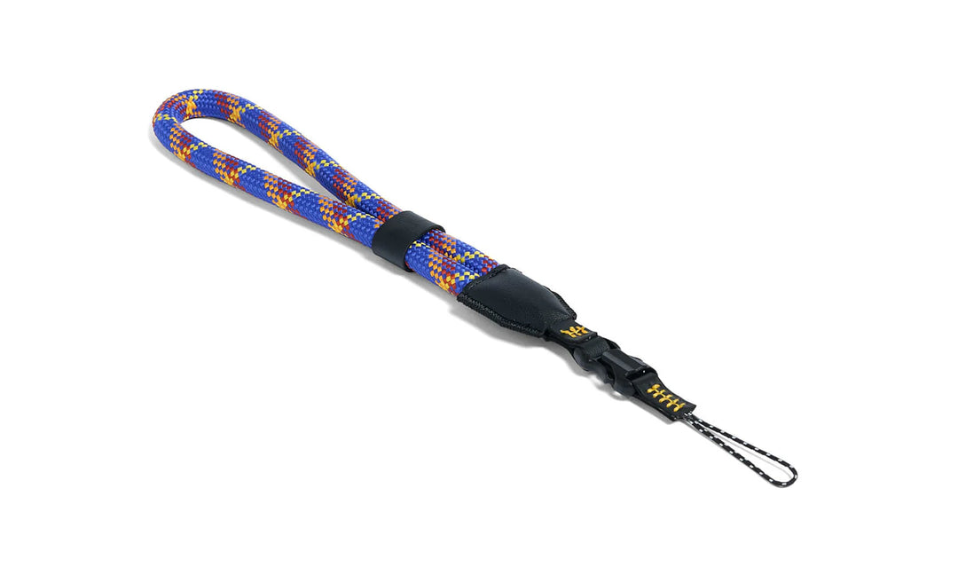 Colorful rope camera strap with a black clip on a white background