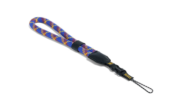 Colorful rope camera strap with a black clip on a white background