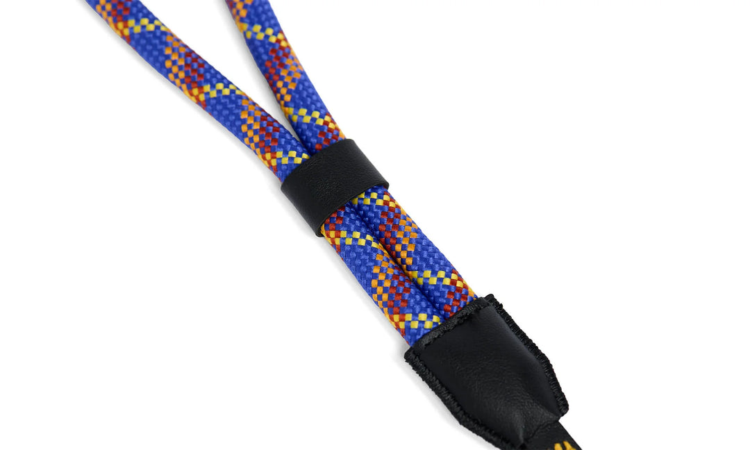 Multicolored braided camera strap with black connectors on a white background