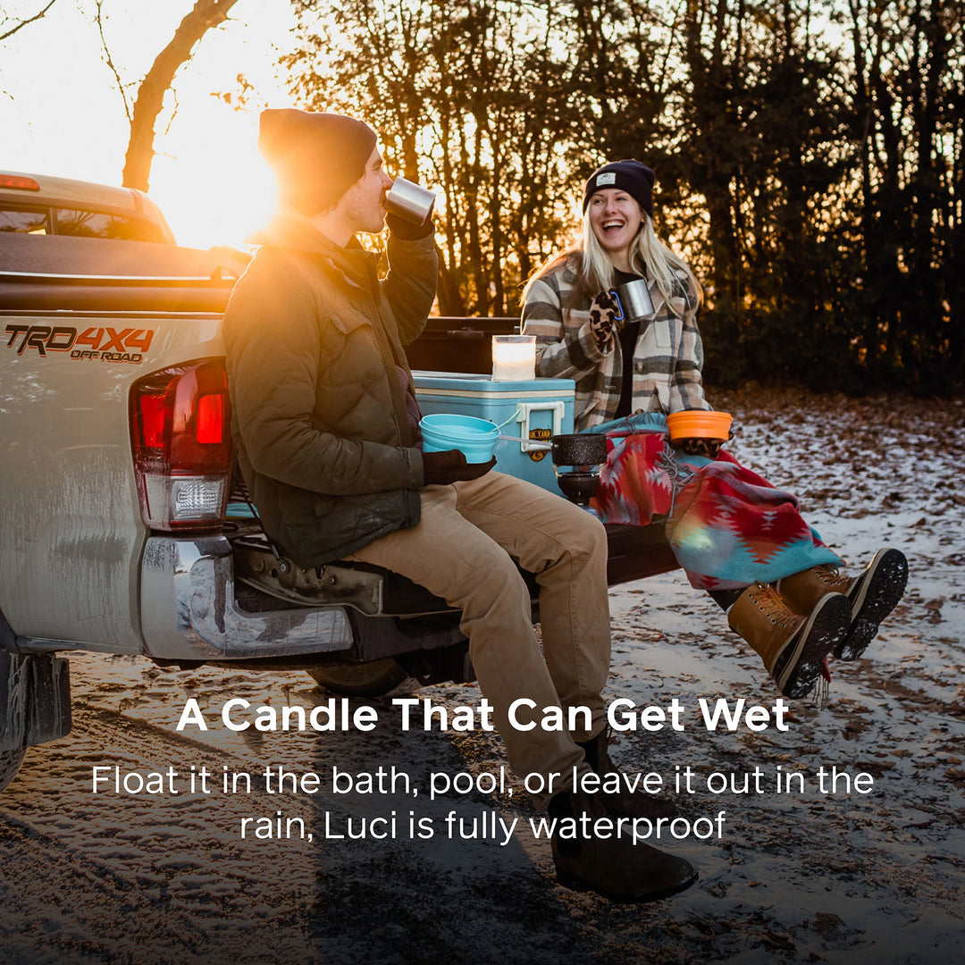 Two people sitting in a truck bed with a product, surrounded by nature.