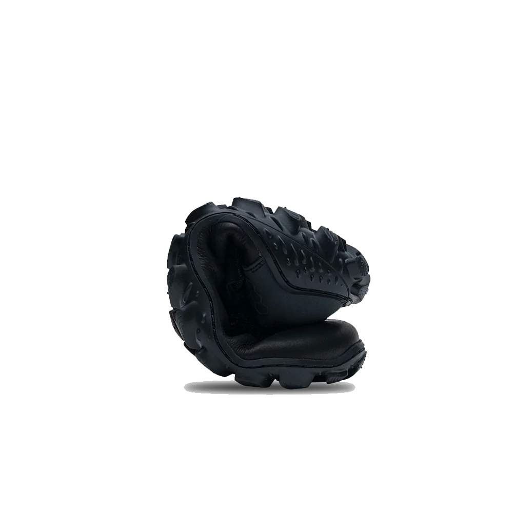 Black shoe rolled up to show flexibility of the sole on a white background 