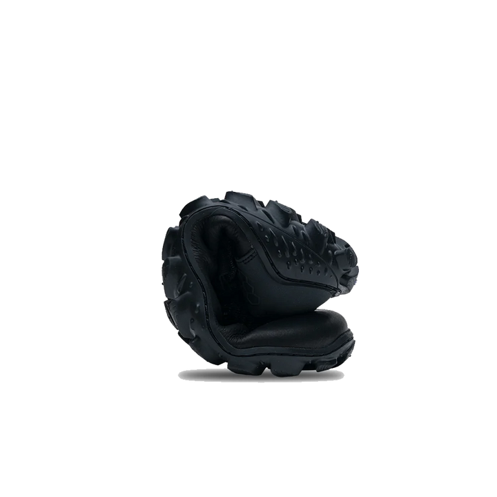 Black shoe rolled up to show flexibility of the sole on a white background 