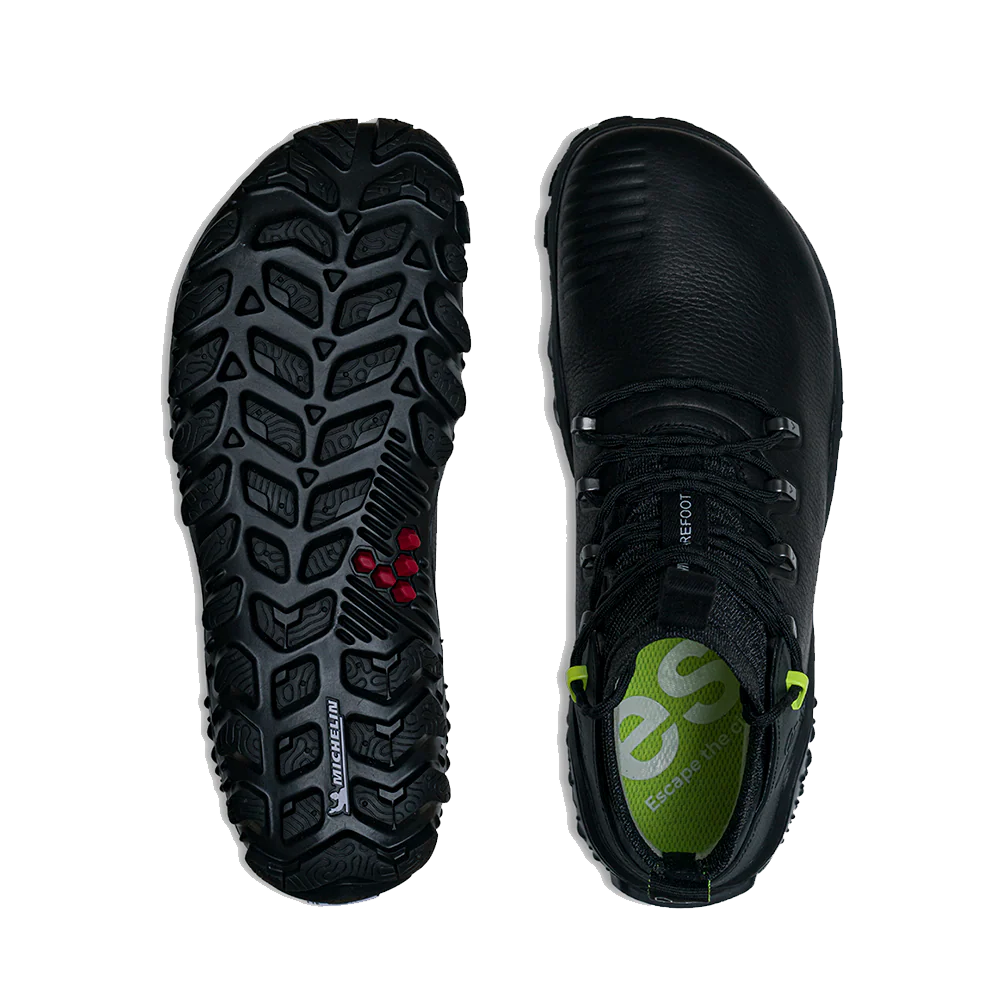 A pair of black outdoor boots shown from the top and bottom against a white background. The left boot displays the rugged black treaded Michelin Outland sole with small red accents, and the right boot shows the black leather upper with a green logo on the tongue.