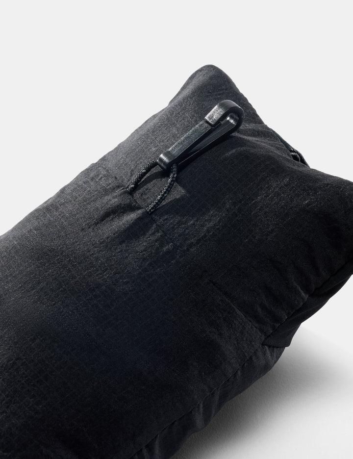 Black travel packed into a small pouch on a light gray background