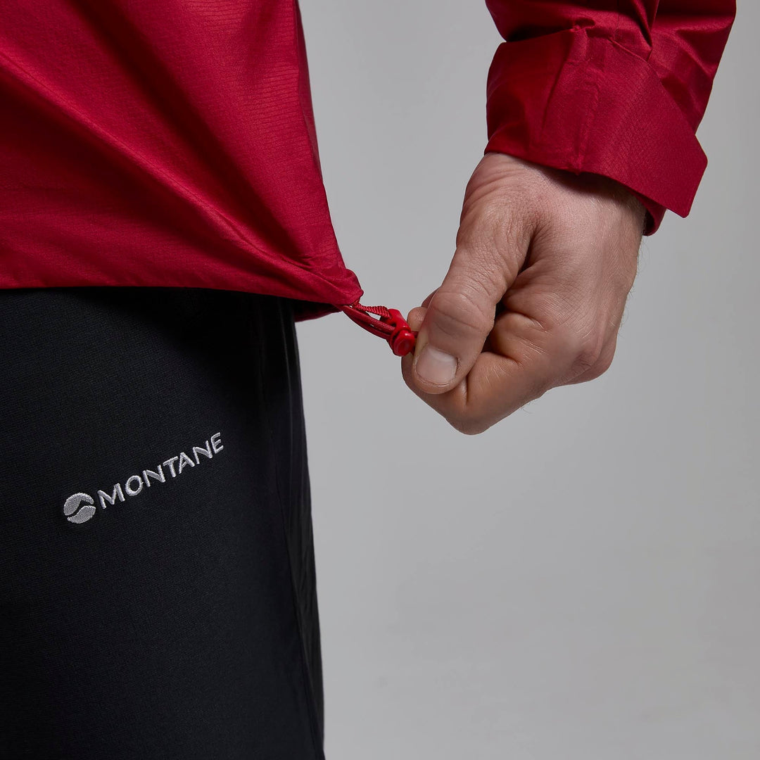 The waist of a raincoat  with a person demonstrating tightening it with elastic and an adjuster