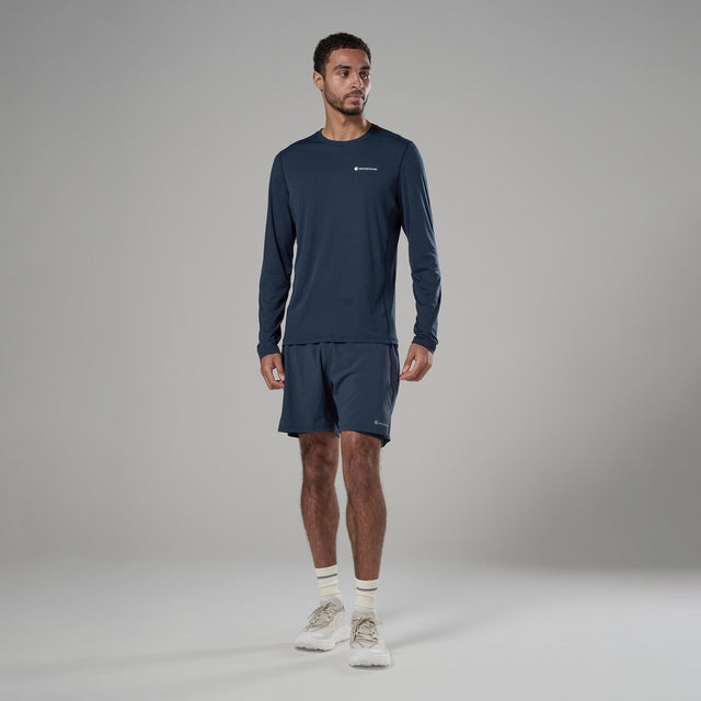 Man wearing a navy long-sleeve athletic shirt and shorts on a gray background