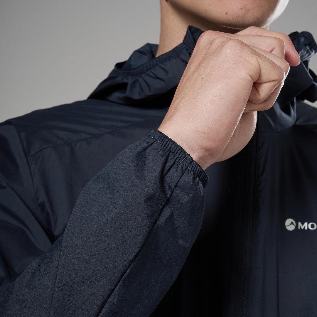 Person wearing a dark blue jacket with a close-up of the sleeve and hand.