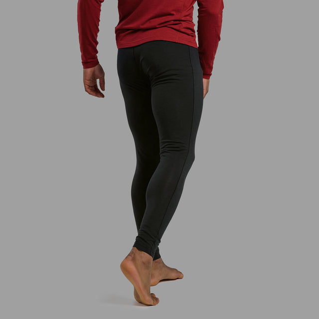 Person wearing black leggings and a red long-sleeve top on a grey background