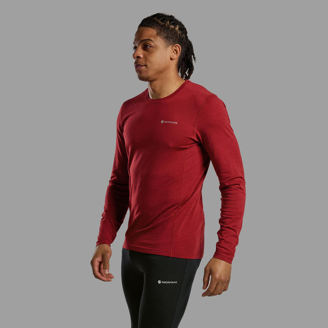 Man wearing a red long-sleeve athletic shirt with a logo on a grey background