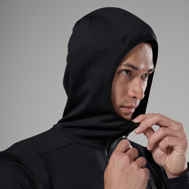 Person wearing a black hooded jacket against a grey background