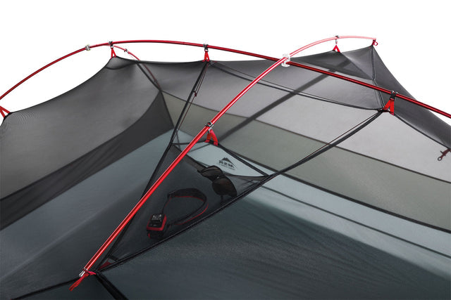Grey camping tent inner with red poles