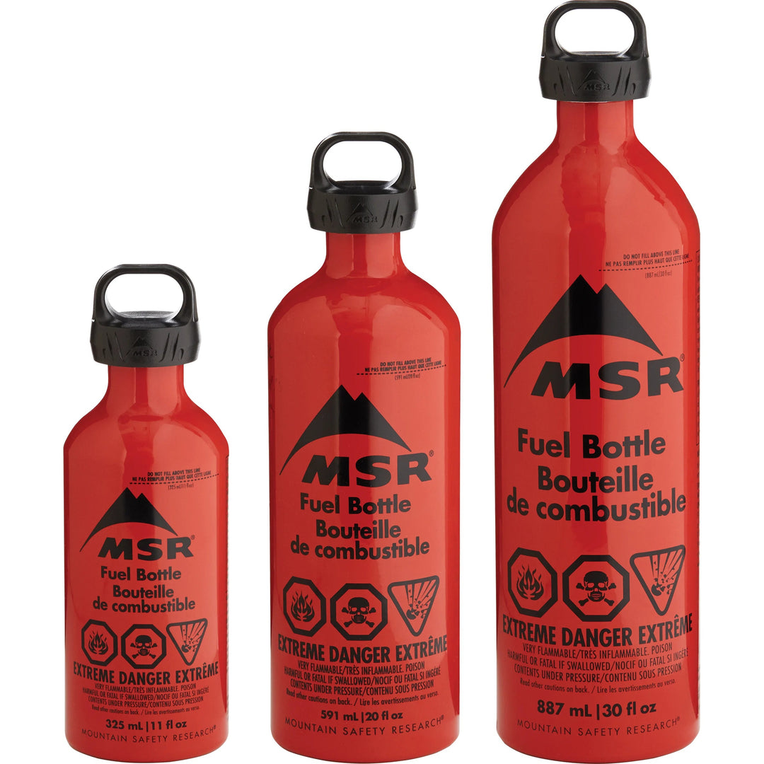 Three red MSR fuel bottles of different sizes on a white background