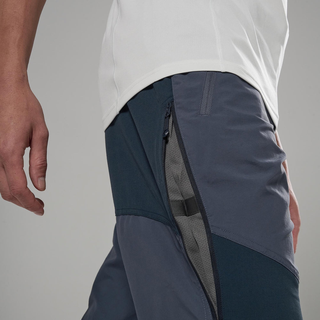 Person wearing dark gray athletic shorts with a white shirt on a gray background