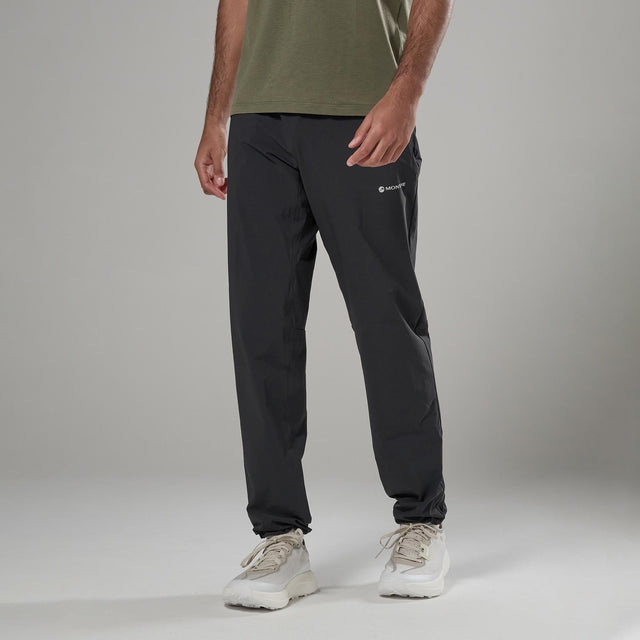 Person wearing a green shirt and black pants with a Montane logo on a grey background