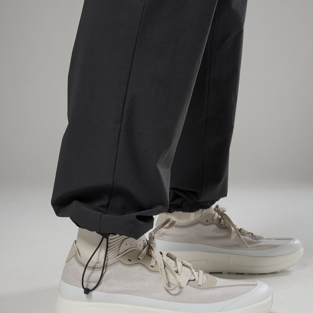 Black pants and white sneakers on a neutral background