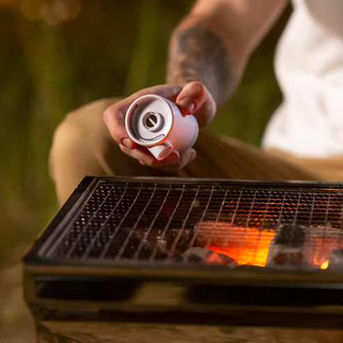 Air pump being used to fan a camp fire
