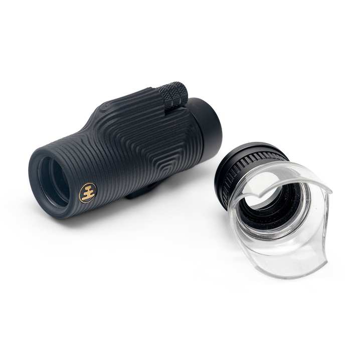 Black monocular telescope with lens cover on a white background
