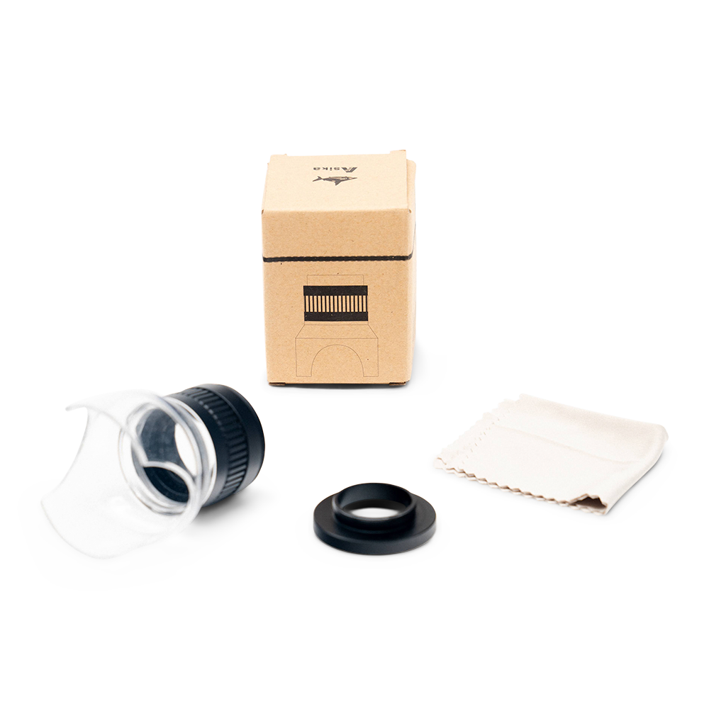 Scope lens, cleaning cloth, and box on a white background