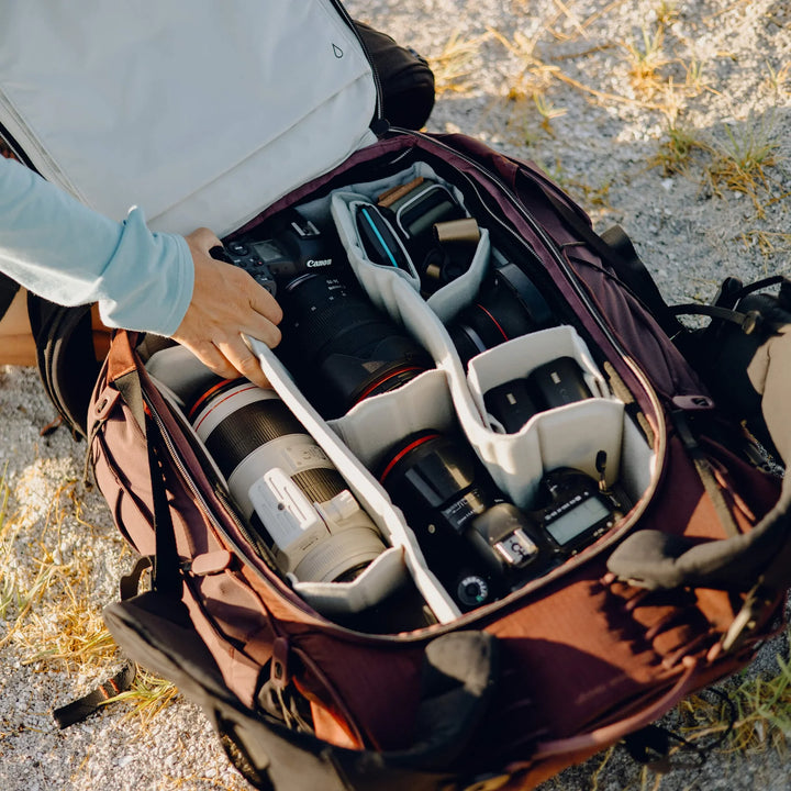 Open camera bag with camera equipment on a natural background