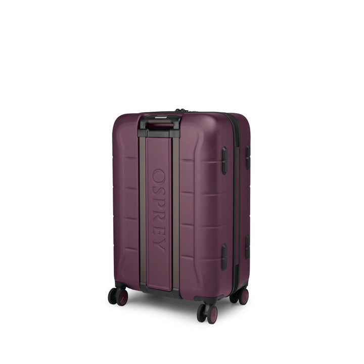 A hard-shell spinner suitcase in a deep plum purple color with black trim and the brand name &