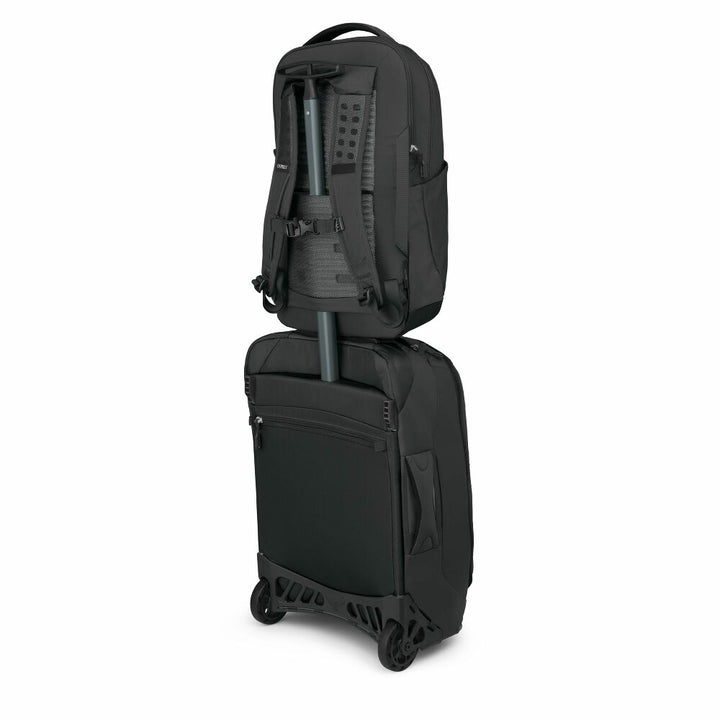 Black backpack and suitcase stacked on a white background