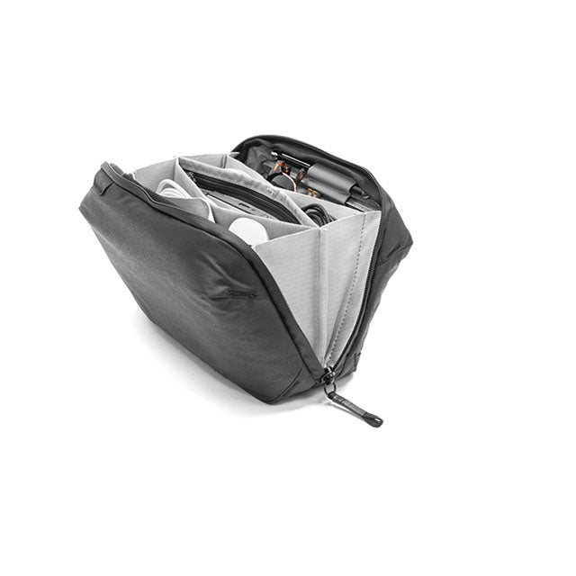 A black and gray camera gear organizer pouch shown open, revealing its interior compartments and zippered pockets, on a clean white background.