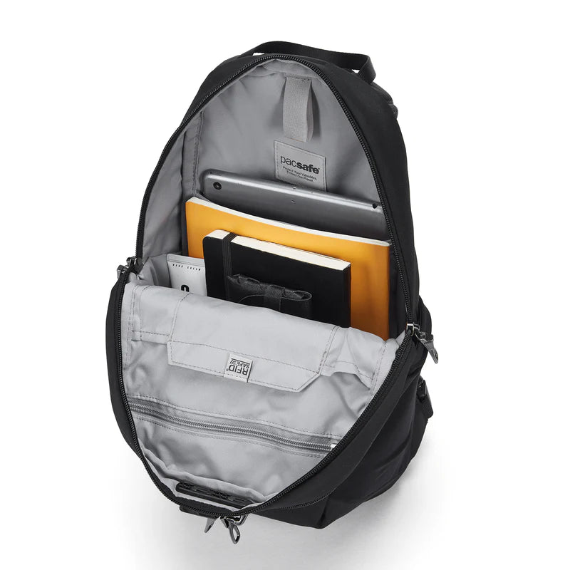 Black backpack with compartments containing a tablet and books on a white background