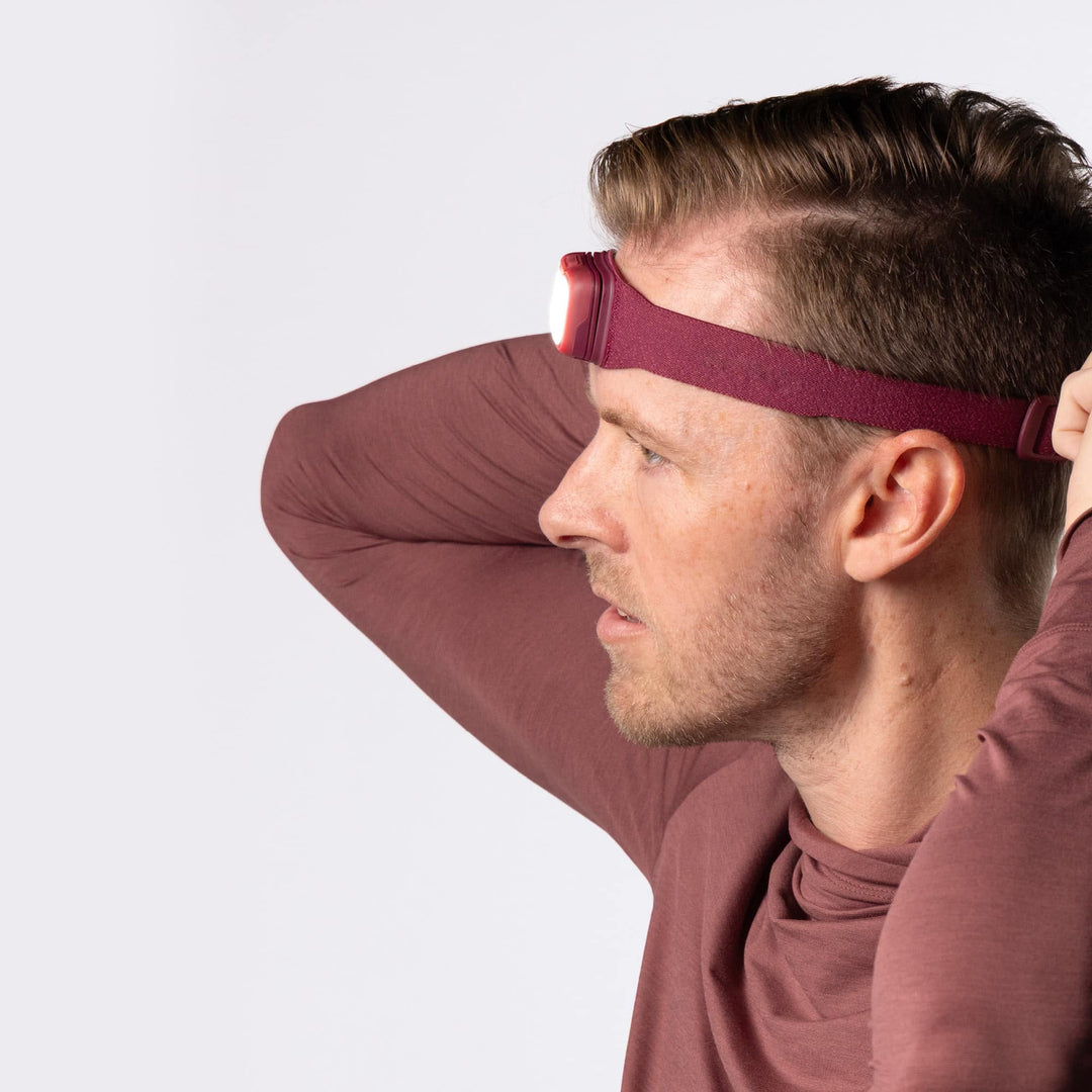 Man wearing a maroon headband against a white background