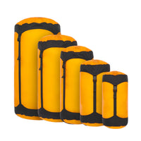 A set of yellow and black Sea to Summit Ultra-Sil compression sacks of various sizes arranged in a row.