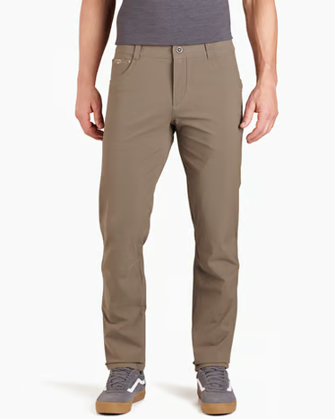 A person wearing slim-fit khaki pants, a gray t-shirt, and gray sneakers, shown from the waist down against a plain white studio background.