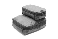 Two gray heather packing cubes stacked on a white background, one larger and one smaller, both with black zippers and dark zipper pulls.